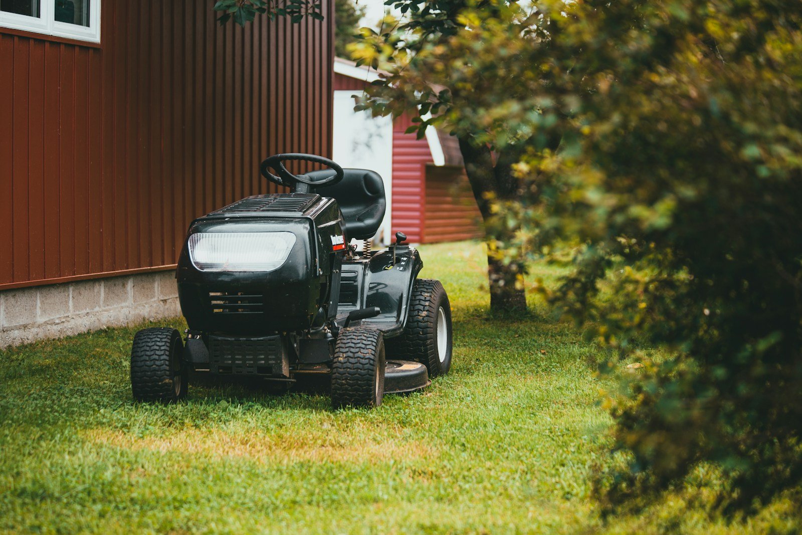 Black ride-on mower on green grass